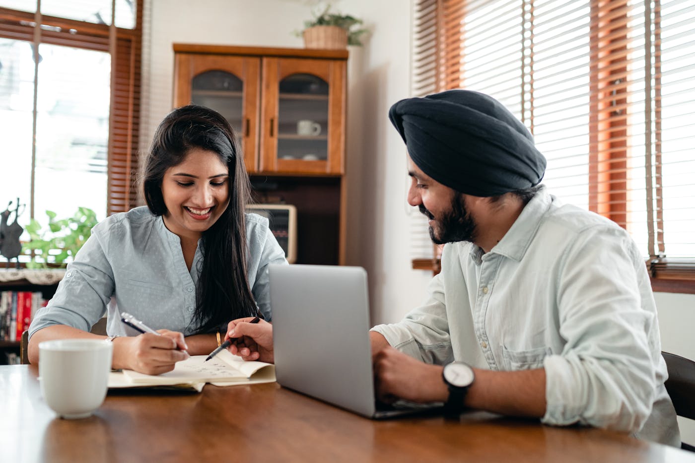 Indian couple discussing financial planning with laptop